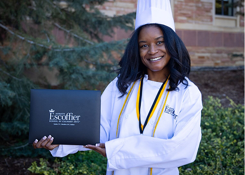 an escoffier culinary school graduate poses with her diploma